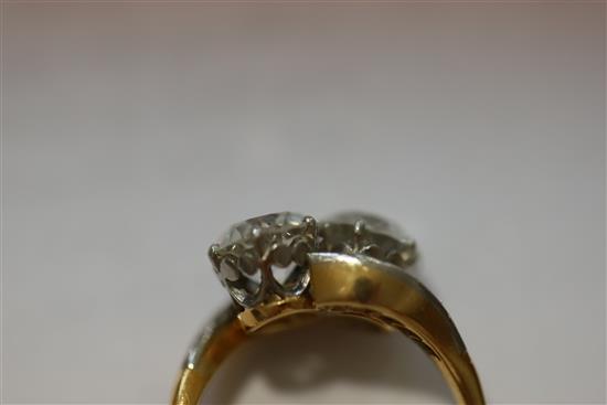 A gold and platinum, two stone diamond crossover ring with diamond set shoulders, size P.